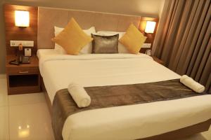 Un pat sau paturi într-o cameră la Hotel Kottayam Grand