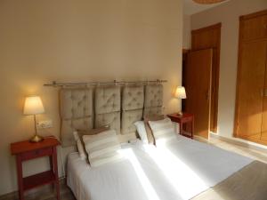 a bedroom with a large white bed with two lamps at Sleepin Sevilla Arenal in Seville