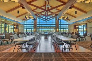 une salle à manger avec des tables, des chaises et des fenêtres dans l'établissement Beautiful Pocono Lake Cottage with Game Room!, à Pocono Lake