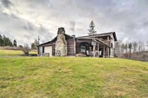 an old log house on a grassy field at New Paris Cabin about 11 Mi to Shawnee State Park 