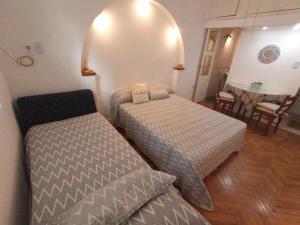 ブエノスアイレスにあるSpring Box Flat Las Cañitasのベッド2台と椅子が備わる小さな客室です。