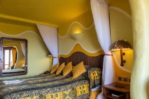 a bedroom with a bed with a large mirror at Mara Serena Safari Lodge in Lolgorien