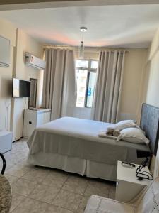 a bedroom with a large bed and a window at Stúdio Beira Mar in Fortaleza