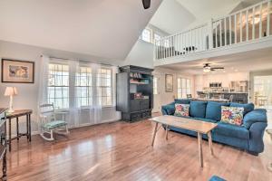 ein Wohnzimmer mit einem blauen Sofa und einem Tisch in der Unterkunft Country-Chic Home with Fire Pit, Steps to Lake! in New Concord