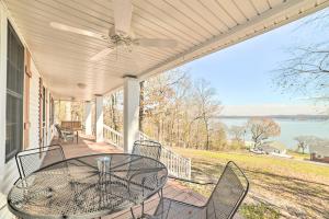 a patio with a table and chairs on a house at Country-Chic Home with Fire Pit, Steps to Lake! in New Concord