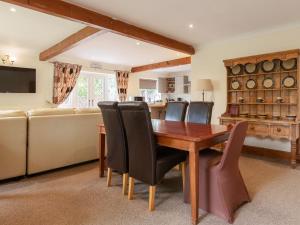 a living room with a wooden table and chairs at Riverside Cottage-uk41439 in Brandon
