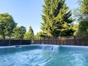 a hot tub in a backyard with a tree at Riverside Cottage-uk41439 in Brandon