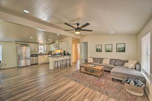 a living room with a couch and a kitchen at Munds Park Cabin with Wraparound Deck and Grill! in Munds Park