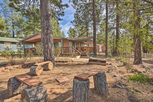 a house with trees and benches in the yard at Munds Park Cabin with Wraparound Deck and Grill! in Munds Park