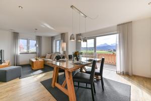 - une salle à manger et un salon avec une table et des chaises dans l'établissement Landhaus am See Appartement LH 02, à Schwangau