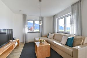 a living room with a couch and a tv at Landhaus am See Appartement LH 02 in Schwangau