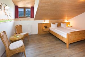 1 dormitorio con 1 cama, mesa y sillas en Salenberghof Ferienwohnung Bergsee, en Rieden