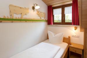 a small room with a bed and a window at Salenberghof Ferienwohnung Traumblick in Rieden am Forggensee