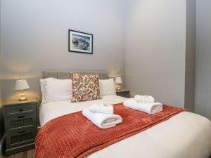 ein Schlafzimmer mit einem Bett mit Handtüchern darauf in der Unterkunft 2 Oak Park in Tiverton