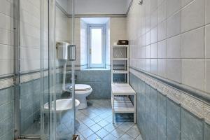 La salle de bains est pourvue de toilettes et d'une douche en verre. dans l'établissement Casa al Viminale, à Rome