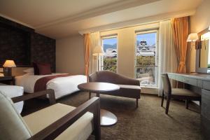 熊本市にある熊本ホテルキャッスルのベッド2台と窓が備わるホテルルームです。