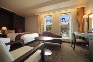 a hotel room with two beds and a window at Kumamoto Hotel Castle in Kumamoto