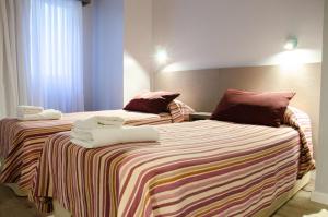 two beds in a hotel room with towels on them at Hotel Vip´s in Mar del Plata