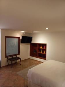 a bedroom with a bed and a flat screen tv at Marhialja Hotel Boutique in Oaxaca City