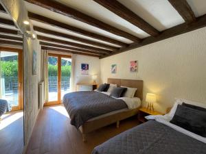 a bedroom with two beds in a room with windows at Chalet Chantelle in Morzine