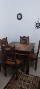 a wooden dining room table and chairs with a clock on the wall at Shamokh House in Acre