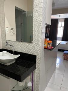 a bathroom with a sink and a mirror at Stúdio Beira Mar in Fortaleza