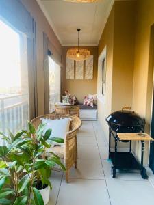 a room with a table and chairs on a balcony at Abusar Apartment in Boksburg