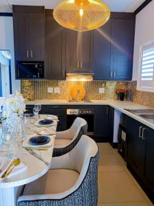 a kitchen with a table with chairs and a chandelier at Abusar Apartment in Boksburg