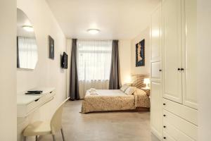 Schlafzimmer mit einem Bett, einem Schreibtisch und einem Fenster in der Unterkunft Vincanto Rooms Old Town in Prag