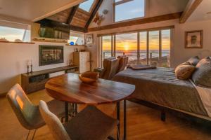 a bedroom with a bed and a table and chairs at Spectacular Oceanfront Studio with Hot Tub & Loft in Fort Bragg