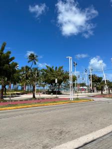 an empty street with palm trees and a blue sky at Stúdio Beira Mar in Fortaleza