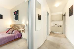 a bedroom with a bed and a hallway with a kitchen at Vincanto Rooms Old Town in Prague