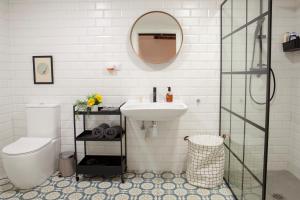 een badkamer met een wastafel, een toilet en een spiegel bij B - NOGUERA APARTMENTS - ARTS AND SCIENCIES in Valencia