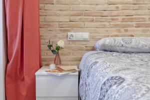 a bedroom with a bed and a brick wall at B - NOGUERA APARTMENTS - ARTS AND SCIENCIES in Valencia