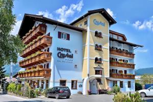 un hotel con un coche aparcado delante de él en Hotel Crystal - KitzHorn Suites, en Sankt Johann in Tirol