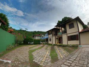 a cobblestone driveway in front of a house at Recanto Vicks Flats in Ilhabela