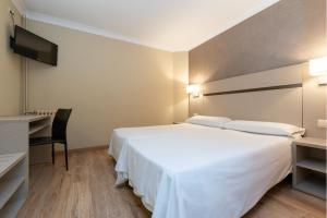 Rúm í herbergi á Hotel & Aparthotel Cosmos