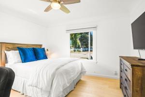 a bedroom with a bed with blue pillows and a tv at Mid-Town Escape in Ventura