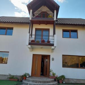 a white house with a balcony and a door at Alexandra&Alex in Horezu