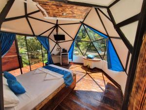 Zimmer mit einem Bett in einem Zelt mit Fenstern in der Unterkunft Glamping Tomaselli in Manuel Antonio