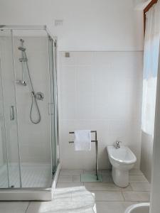 y baño con ducha, aseo y lavamanos. en B&B La finestra sul porto, en Porto Torres