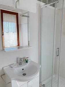 y baño blanco con lavabo y ducha. en B&B La finestra sul porto, en Porto Torres