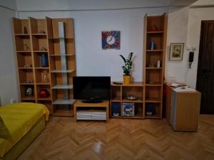 a living room with a television and wooden shelves at Spectacular apartment in Skopje, City Mall area in Skopje