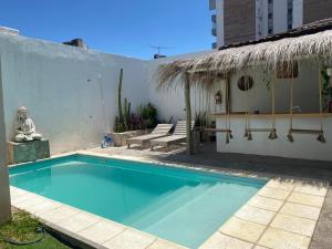 a swimming pool in front of a white wall with aitating at Bardot Hostel in Paraná