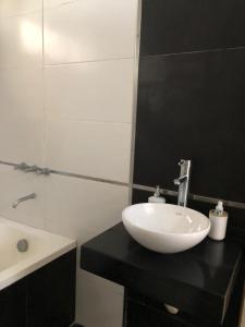 baño con lavabo blanco y encimera negra en Quinta al sur - Quinta con pileta en Paraná en Paraná