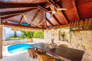 an outdoor dining room with a table and a swimming pool at Apartmani Gabi in Njivice