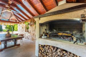 an outdoor kitchen with a large stone oven at Apartmani Gabi in Njivice