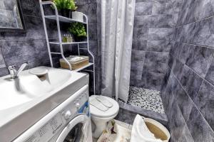 ein Bad mit einem Waschbecken, einem WC und einer Dusche in der Unterkunft Комфортная квартира в центре города in Astana