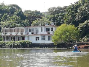 a person on a raft in the water in front of a house at La Cabaña del Lago in Catemaco +39 photos