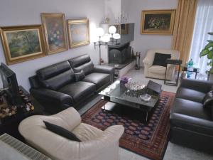 sala de estar con muebles de cuero negro y chimenea en Villa in Panorama, Thessaloniki, with a swimming pool. Host: Mr. George, en Tesalónica